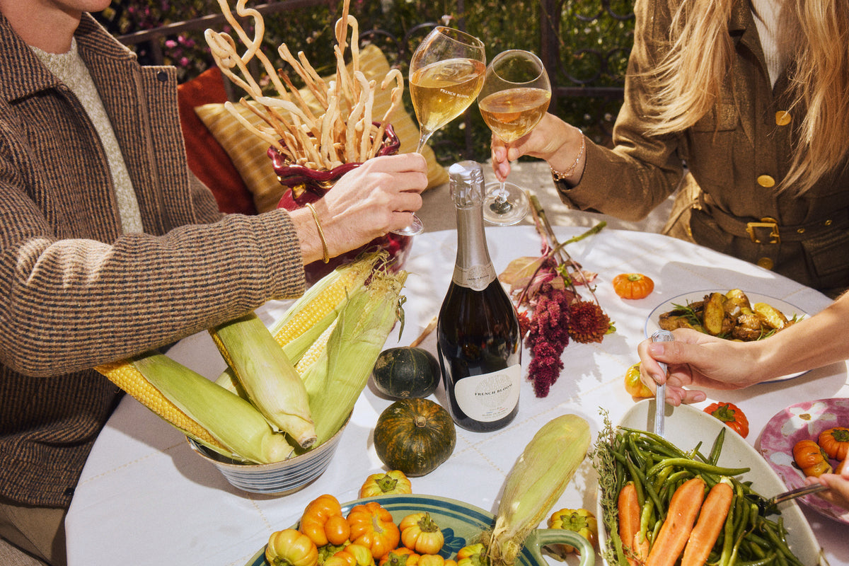 Des amis lèvent leur verre de French Bloom autour d’une table d’automne