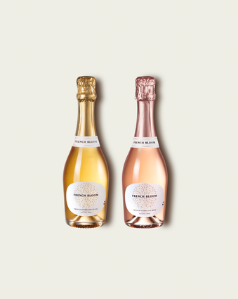 Two French Bloom half bottles, Le Blanc with pale golden liquid and a metallic gold foil top and Le Rosé with pale pink liquid and a metallic rose-gold foil top, set against a light warm-gray background.