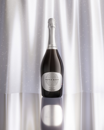 French Bloom Extra Brut bottle against an elegant silver luminous background.