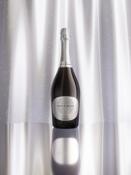 French Bloom Extra Brut bottle against an elegant silver luminous background.