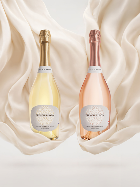 French Bloom Le Blanc and Le Rosé bottles set against flowing ivory fabric.